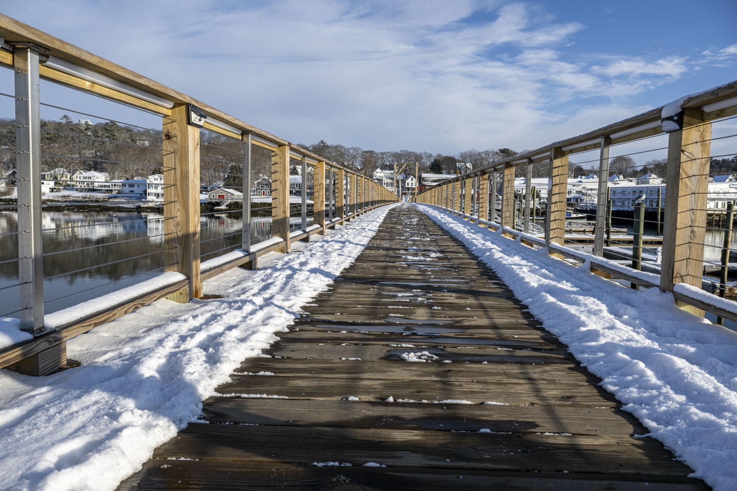 The footbridge itself has snow along each edge.