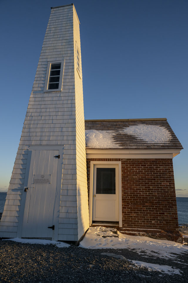 The bell house has a bit of snow on the roof.