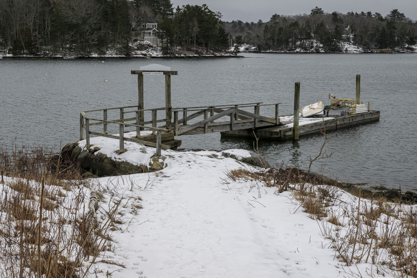 A snowy path leads to a pier that has a sign that says Dawes Landing.