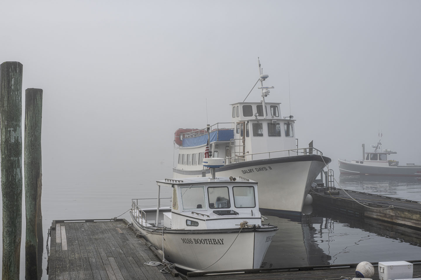 The smaller boat Miss Boothbay and the larger boat Balmy Days II are moored on docks.