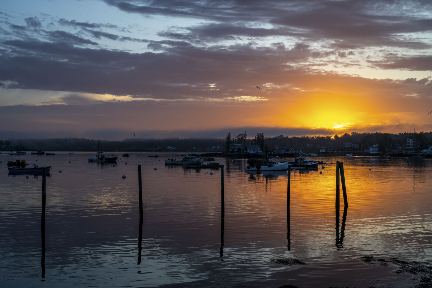 The setting sun illuminates the water and the clouds.
