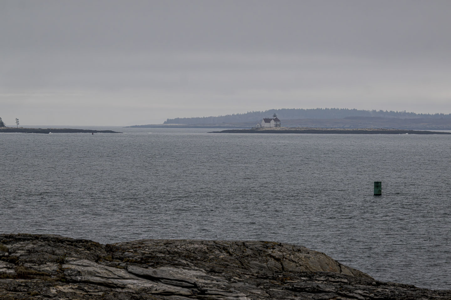 Looking over what seems to be a short amount of water at a lighthouse.