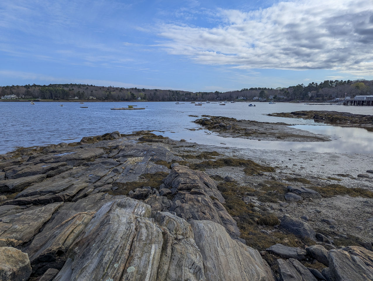 Looking down a rock formation, water with boats can be seen.