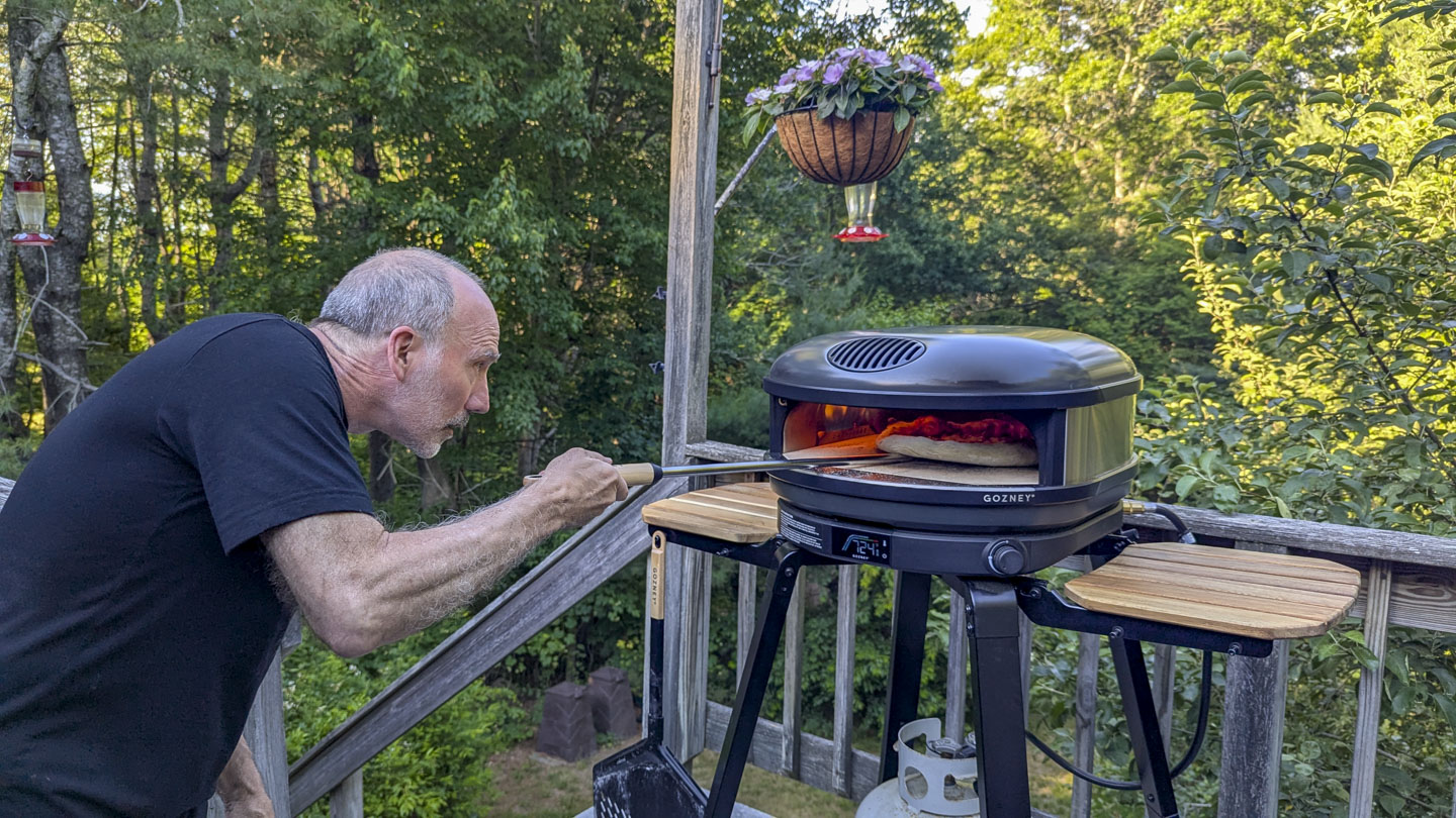 Paul is turning the pizza.