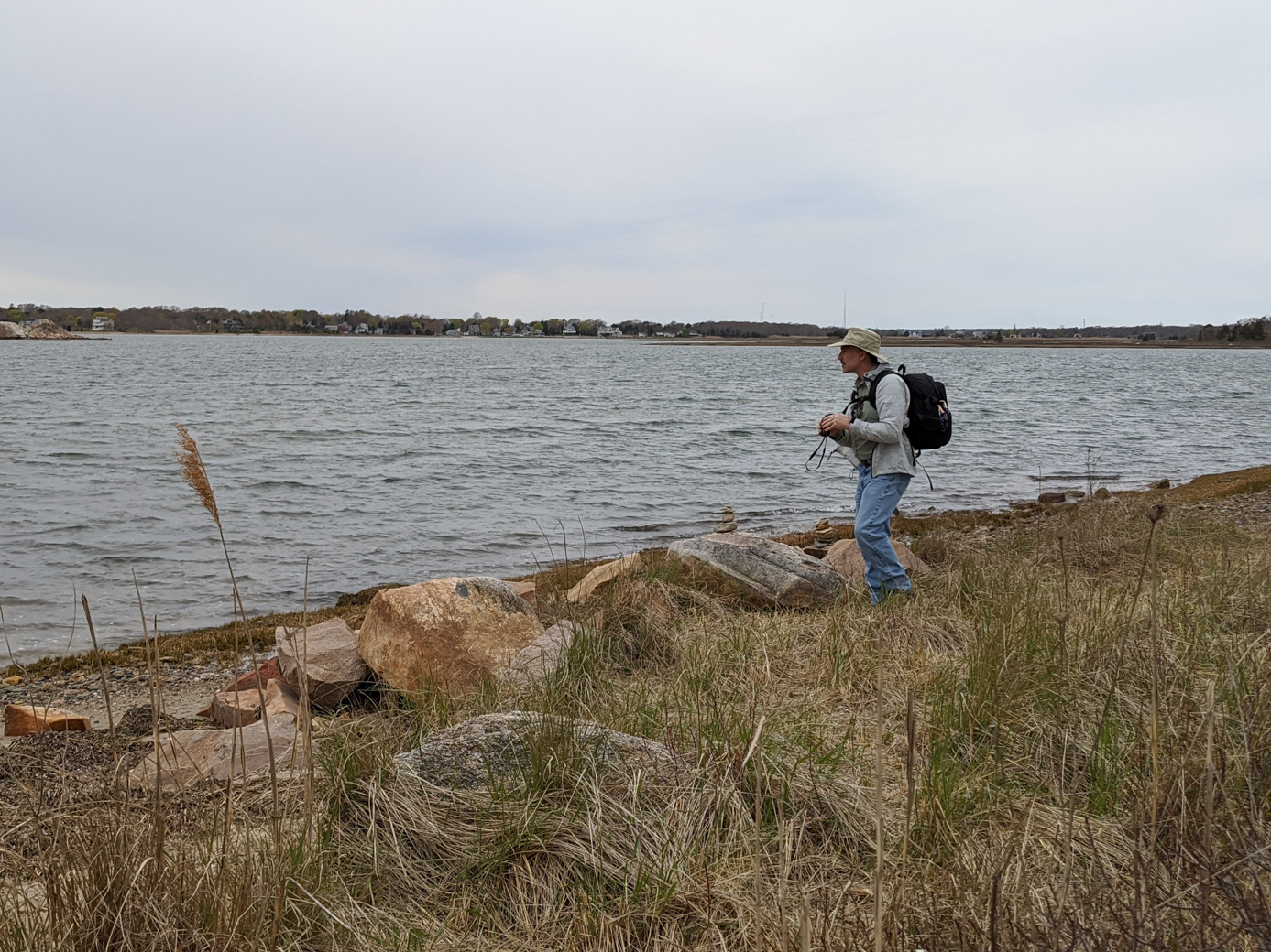 Paul on the beach carrying binoculars and backpack