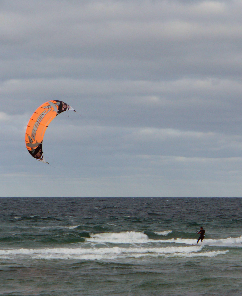 Man in wetsuit windsurfing at Scusset Beach